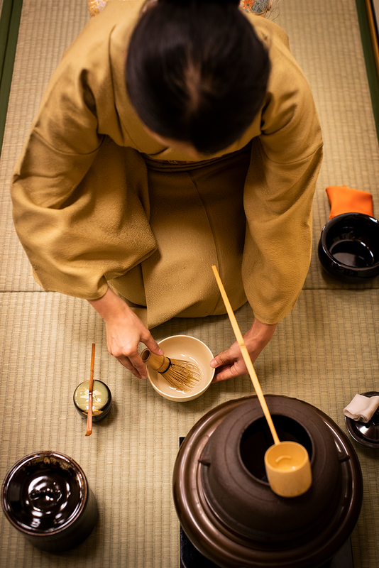 woman shown from above demonstrating a tea ceremony