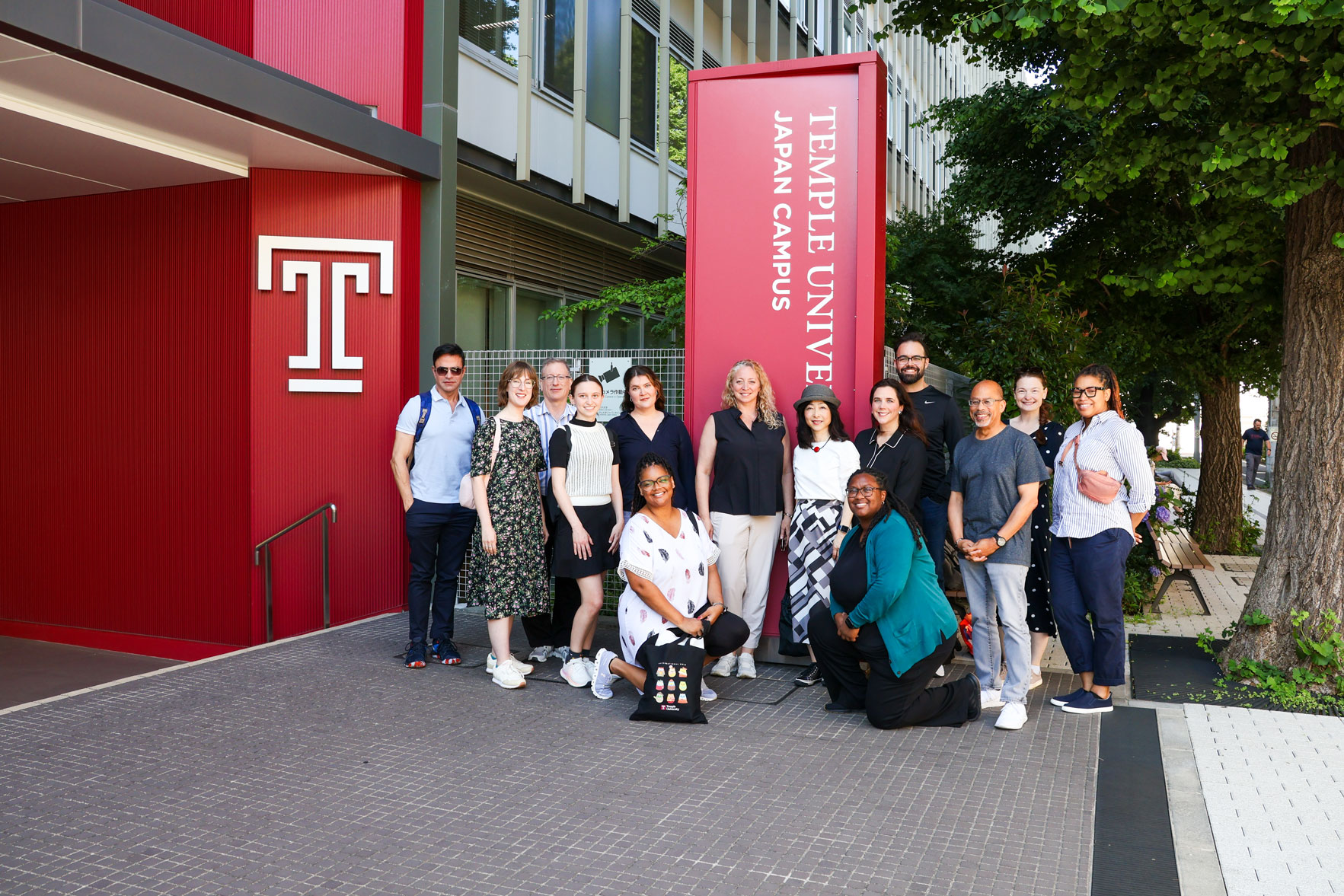 Representatives of four partner universities and 10 counselors from Temple’s Main Campus pose for a group photo in front of TUJ’s main entrance.