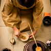woman shown from above demonstrating a tea ceremony