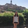 Photo of Brook Quinn against a cityscape of Siena, Italy