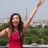 Photo of Jenny Wang with arms extended, Eiffel Tower in the background