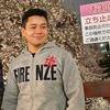 Photo of Jonathen standing in front of cherry blossoms in Tokyo