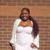 Monica posing in front of a brick wall